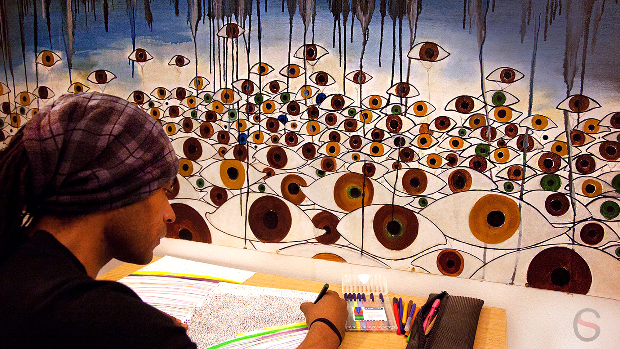 Carlos Simpson seated in profile during a reflective drawing session, focused on mark-making and creative process.